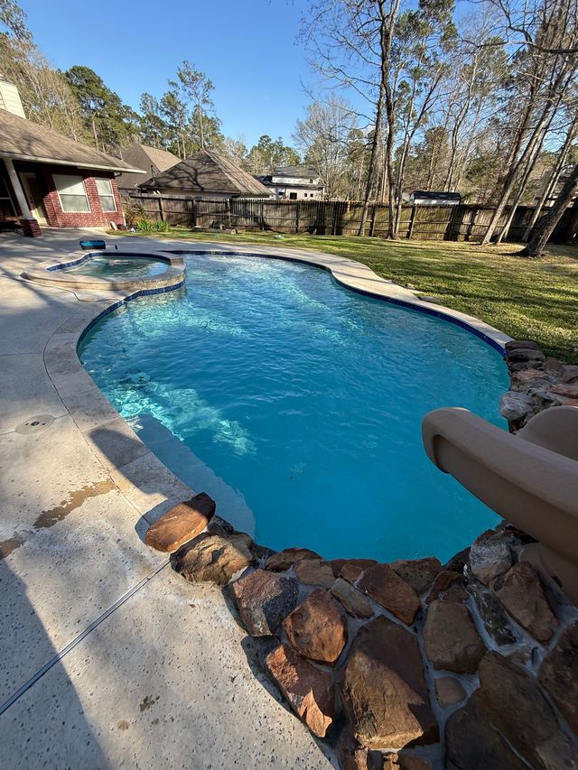 After: the same pool seen from the slide, clear blue water and a clean floor beside the rock edging