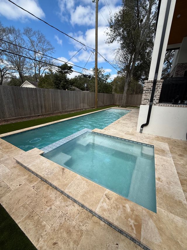 After: the same spa with clear water and a clean travertine edge